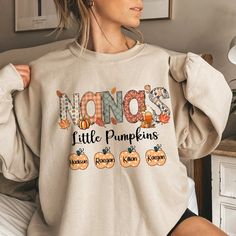 Mimi's Little Pumpkins Grandkids TTD T-Shirt If you looking for a personalized t-shirt to show your love to your family, it's will be best choice. Our Classic T-Shirt serves as the perfect short-sleeved shirt for your unique, funny, or personalized designs. Features such as a lay flat collar and a classic unisex cut will make this your new favorite t-shirt. Brand: Gildan Heavy weight fabric Classic unisex makes this an easy fit Size up if you want something roomier Our shirts include: - Sport Grey And Antique Heathers: 90% Cotton | 10% Polyester - Safety Colors And Heathers: 50% Cotton | 50% Polyester - Another colors: 100% cotton Machine wash cold inside out with like colors, tumble dry low for easy care Thankful Sweatshirt, Pumpkin Sweatshirts, Custom Sweatshirts, Fall Sweatshirt, Design T Shirt, Carolina Blue, Heather Black, Long Sleeve Knit, Sweatshirt Fashion