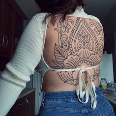 the back of a woman's body with tattoos on her upper and lower half