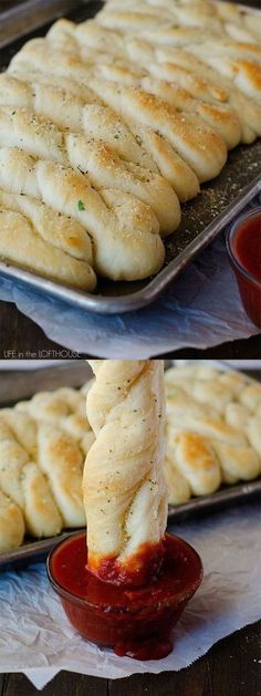 bread sticks being dipped with ketchup in a bowl and on a baking sheet