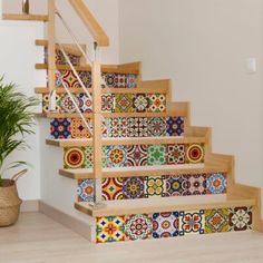 the stairs are decorated with colorful tiles and potted plant on the floor next to them