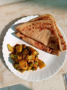 two pieces of pita bread and some vegetables on a plate