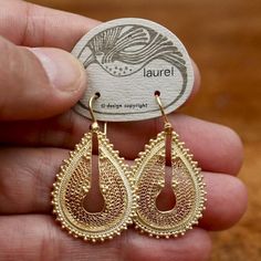 Indian inspired dangles featuring filigree and granule work in a teardrop shape. Hoop back. 24k gold over brass base. About 2 inches tall.The revival earrings here are vintage from the 1970's - they were designed by Shashi Singapuri for the Laurel Inc line and crafted by hand. Artisan Gold Teardrop Pendant Jewelry, Traditional Fair Trade Gold Jewelry, Filigree Teardrop Chandelier Earrings, Teardrop Filigree Chandelier Earrings, Gold Brass Chandelier Earrings With Intricate Design, Artisan Gold Earrings With Intricate Design, Artisan Gold Teardrop Earrings, Ornate Brass Teardrop Earrings, Ornate Teardrop Brass Earrings