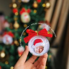 someone holding up a christmas ornament with a baby's photo on it