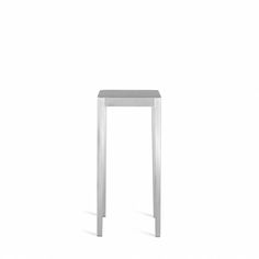 a small white table with one leg up against the wall and two legs down to the floor