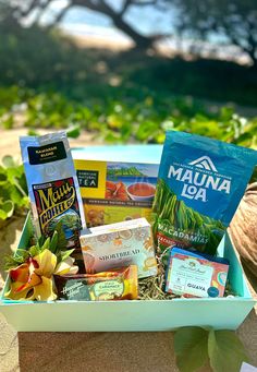 a box filled with tea and snacks sitting on top of a table next to plants