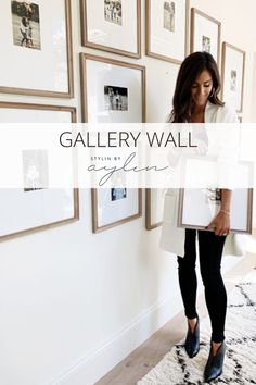 a woman standing in front of a wall with pictures on it