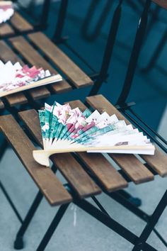 three wooden tables with different colored papers on them and one has a fan shaped like a flower