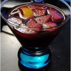 a close up of a drink in a glass with ice and fruit on the rim