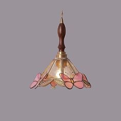 a light fixture with pink flowers on it and a wooden handle hanging from the ceiling