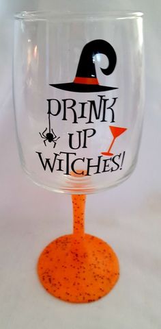 a wine glass with the words drink up witches on it and a witch's hat