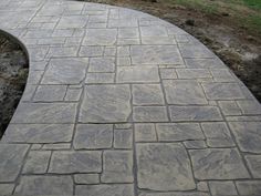 a stone walkway in the middle of a grassy area next to a fire hydrant