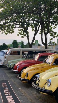 a row of old cars parked next to each other on the side of a road