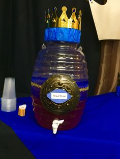 a plastic container with a crown on top sitting on a table next to other items