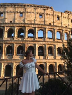 a woman standing in front of the colossion with her hands on her hips