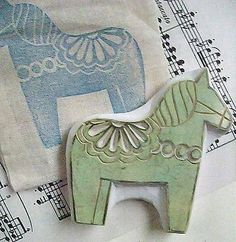 two wooden horses sitting on top of sheet music paper with musical notes in the background