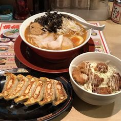 two bowls of food on a table with chopsticks next to one bowl filled with soup