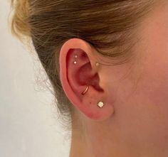 a close up of a person's ear with two piercings