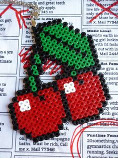 a pair of red and green beaded boxing gloves on top of a news paper