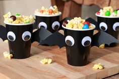 some black cups filled with popcorn and bats