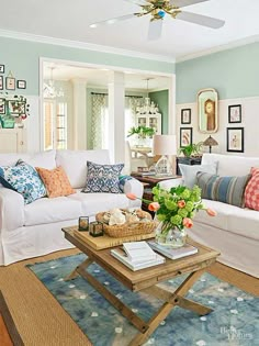 a living room filled with white furniture and lots of pillows on top of it's couches