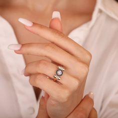 a woman in white shirt holding onto her engagement ring