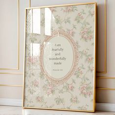 a frame with a quote on it sitting in front of a wallpapered background