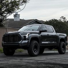 a black truck parked in front of a house