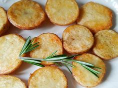 small crackers with rosemary sprigs are on a white plate, ready to be eaten