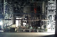 an industrial machine room with lots of machines in it's display case and lights on the wall