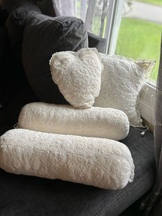 three pillows stacked on top of each other in front of a window