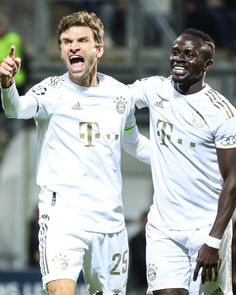 two soccer players standing next to each other with their mouths open and one holding his fist up