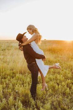 a man holding a woman in the middle of a field