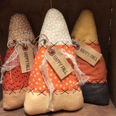 four different colored shoes with tags on them sitting in a wooden box next to each other