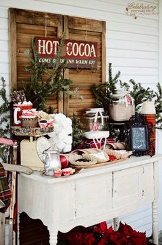 a white table topped with lots of food and christmas decorations next to a sign that says hot cocoa