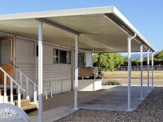 a covered patio with white railings and steps