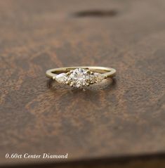 a close up of a ring on a wooden table with a diamond in the middle