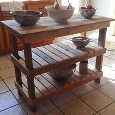 a kitchen island made out of wooden pallets with two bowls on the top and one bowl on the bottom