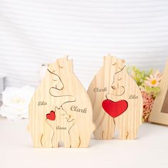 two wooden bears with hearts on their backs, one is holding a heart and the other has a photo frame