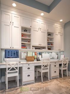 a home office with white cabinets and drawers