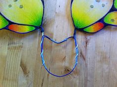 a close up of a butterfly shaped object on a wooden surface