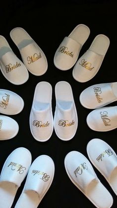 six pairs of white slippers with bride's names written on the soles