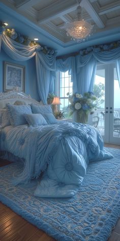 a large bed in a bedroom with blue walls and drapes on the windowsill