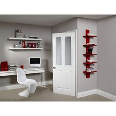 a room with a desk, chair and computer on the wall next to shelves that have bookshelves