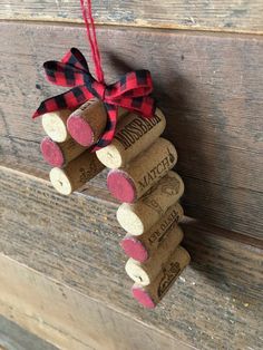 wine cork ornament hanging on wooden planks with red and black plaid ribbon