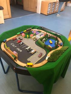 a toy train table with cars and trucks on it