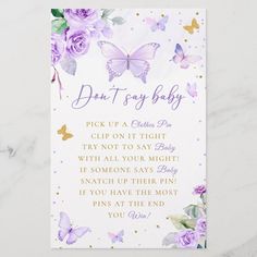 a purple and gold butterfly baby shower sign on a white marble countertop with pink roses