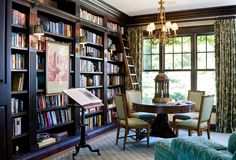 a living room filled with lots of furniture and bookshelves covered in bookcases