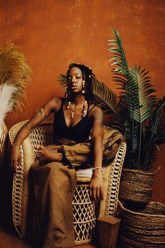 a woman sitting in a chair next to some plants