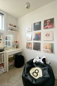 there is a black bean bag in the corner of this room with pictures on the wall