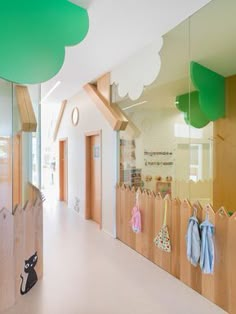 an empty hallway with wooden fence and baby's clothing hanging on hooks